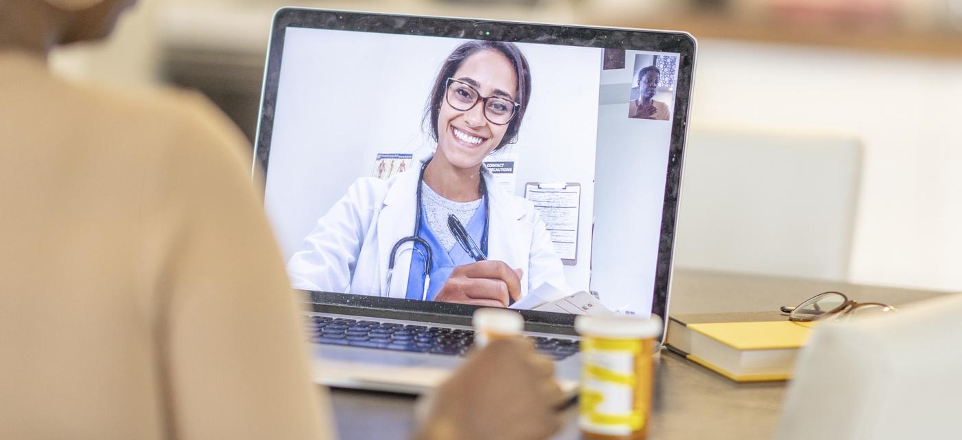 Patient diskuterar med läkare digitalt via laptop.