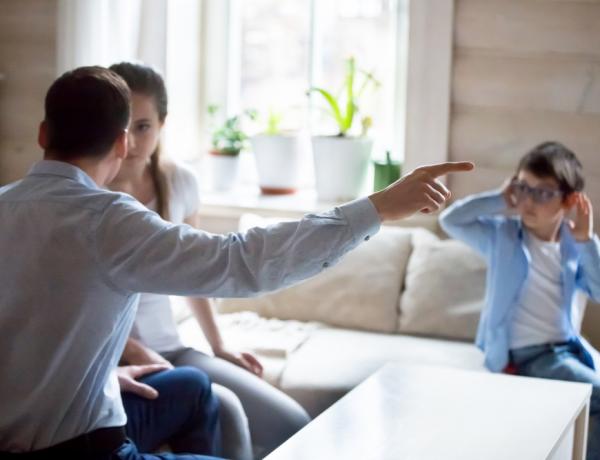 Föräldrar argumenterar hemma framför ett barn som håller för öronen